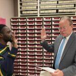 Town and City Clerk Mark Bernacki swearing in Council Clerk of Committees Shayne Livingston.